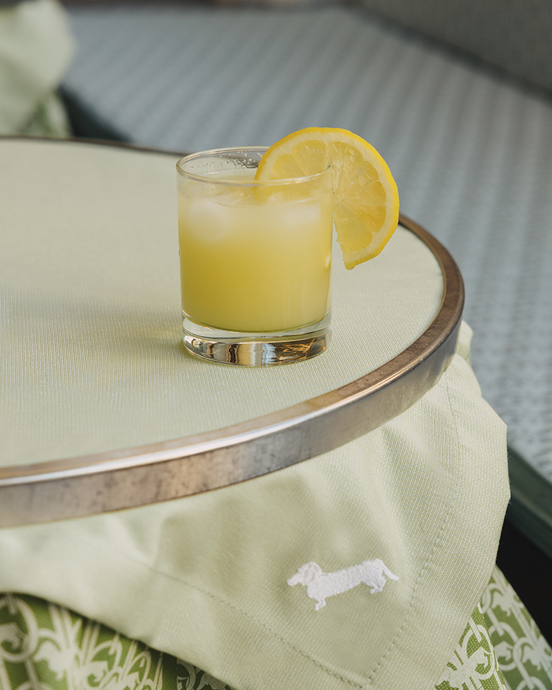 Bicchiere di cocktail con limone su tavolo Harmont & Blaine.