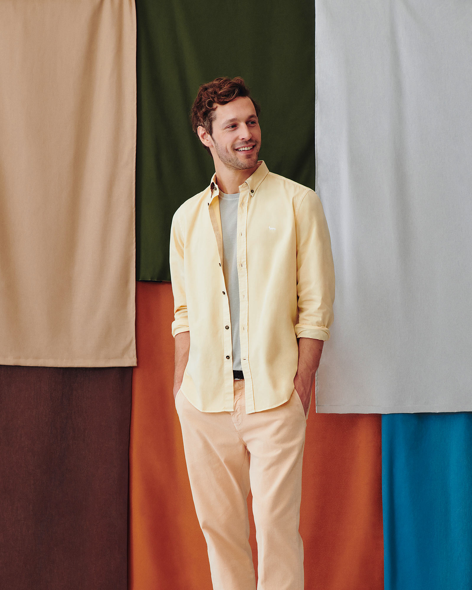 Modello uomo con camicia color pesca e modello donna con cardigan verde oliva e t-shirt rosa.