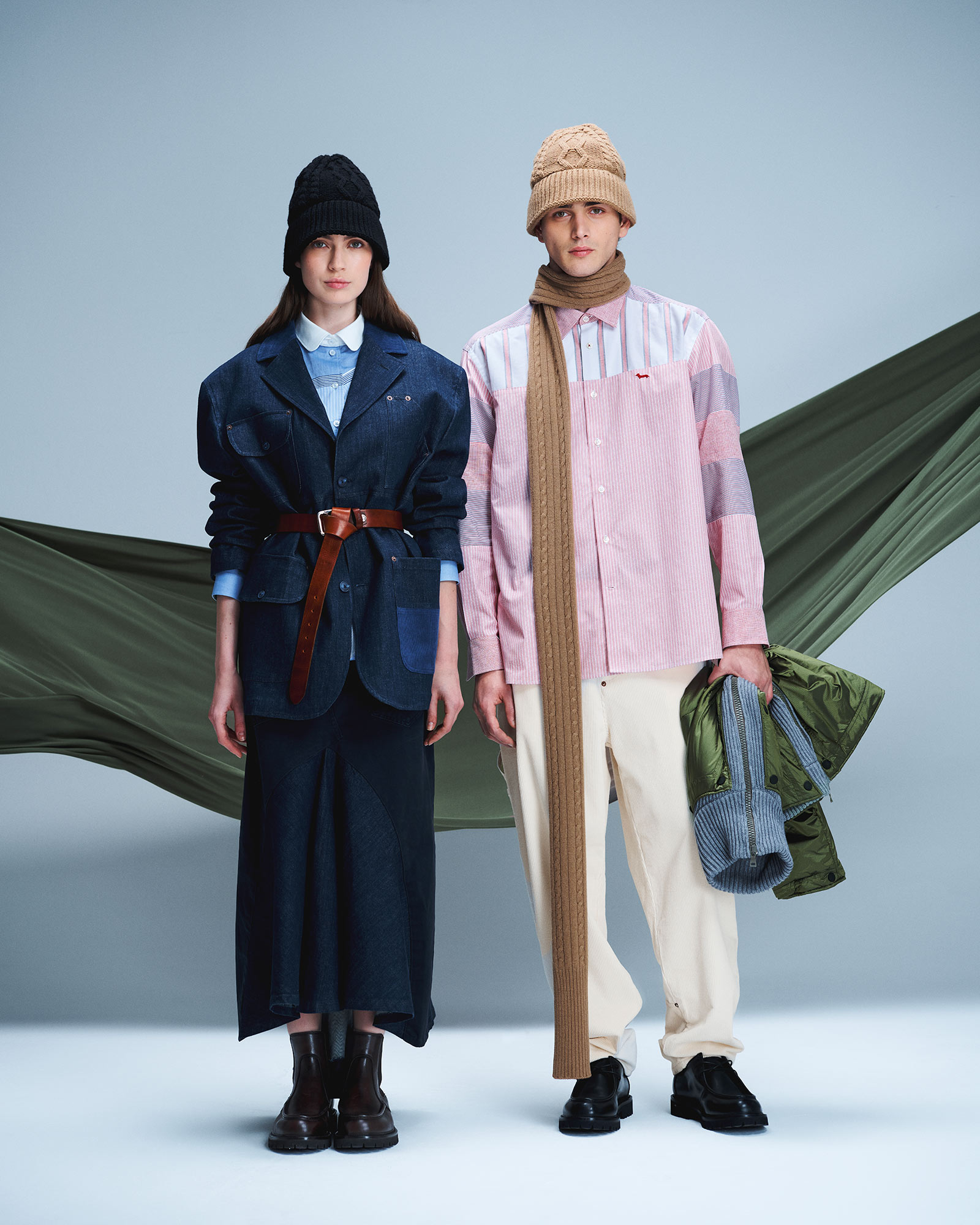 Donna e uomo in denim e camiceria; lei con blazer e gonna in denim, lui con camicia patchwork e pantaloni chiari